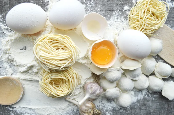 Натюрморт с сырыми домашними макаронами и ингредиентами для макарон.. процесс приготовления pasta.the процесс приготовления домашних пельменей, вкусный обед — стоковое фото