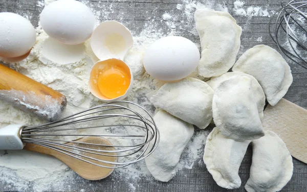 Натюрморт с сырыми домашними макаронами и ингредиентами для макарон.. процесс приготовления pasta.the процесс приготовления домашних пельменей, вкусный обед — стоковое фото