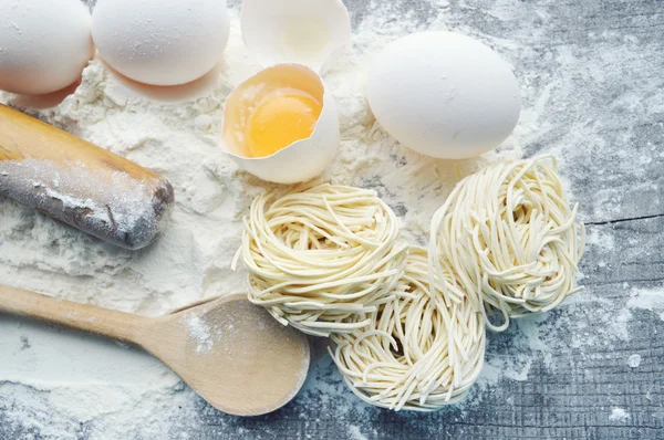 Natura morta con pasta cruda fatta in casa e ingredienti per la pasta.. processo di cottura della pasta.the processo di fare gnocchi fatti in casa, delizioso pranzo — Foto Stock