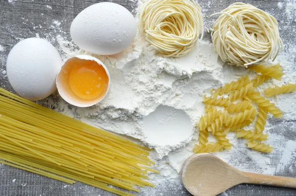 Stilleven met ruwe huisgemaakte pasta en ingrediënten voor pasta... proces van koken pasta — Stockfoto