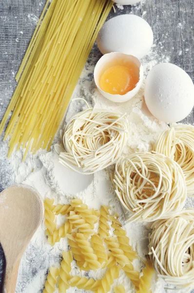 Stilleven met ruwe huisgemaakte pasta en ingrediënten voor pasta... proces van koken pasta — Stockfoto