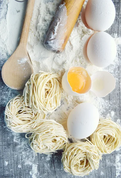 Nature morte avec des pâtes maison crues et des ingrédients pour les pâtes — Photo