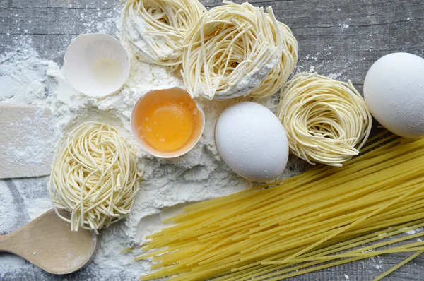 Stilleven met ruwe huisgemaakte pasta en ingrediënten voor pasta... proces van koken pasta — Stockfoto