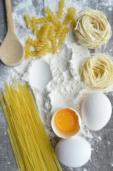 Nature morte avec des pâtes maison crues et des ingrédients pour les pâtes.. processus de cuisson des pâtes — Photo