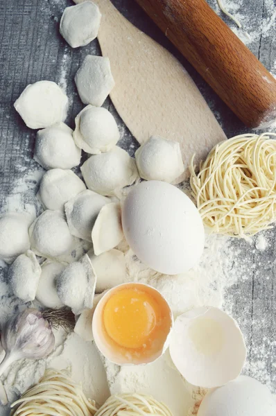 Натюрморт с сырыми домашними макаронами и ингредиентами для макарон.. процесс приготовления pasta.the процесс приготовления домашних пельменей, вкусный обед — стоковое фото