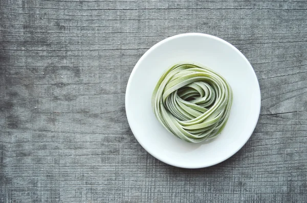 Bunte rohe italienische Pasta auf hölzernem Hintergrund — Stockfoto