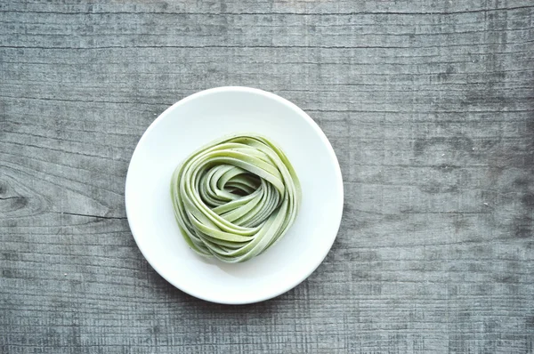 Bunte rohe italienische Pasta auf hölzernem Hintergrund — Stockfoto