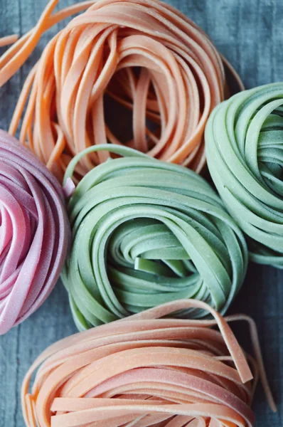 Ahşap arka plan üzerinde renkli ham İtalyan makarna