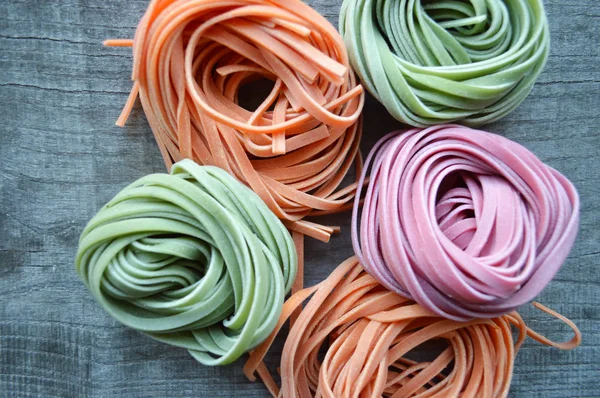 Ahşap arka plan üzerinde renkli ham İtalyan makarna