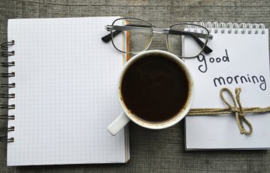 Kırmızı e-gözlük, kitap okuma, not defteri, sıcak kahve ahşap arka plan üzerinde