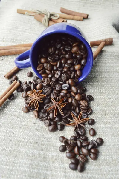 Tasse pleine de grains de café, bâtonnets de cannelle, anis étoilé, gros plan — Photo