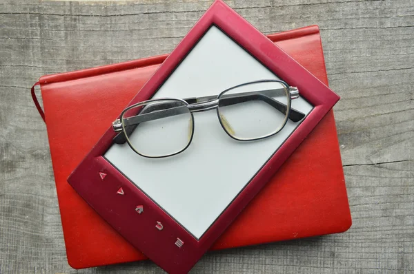 E-book.Notepad,reading glasses,hot Cup of coffee on wooden background. — Stock Photo, Image