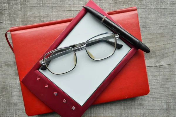 E-book.Blocco note, occhiali da lettura, tazza di caffè caldo su sfondo di legno . — Foto Stock