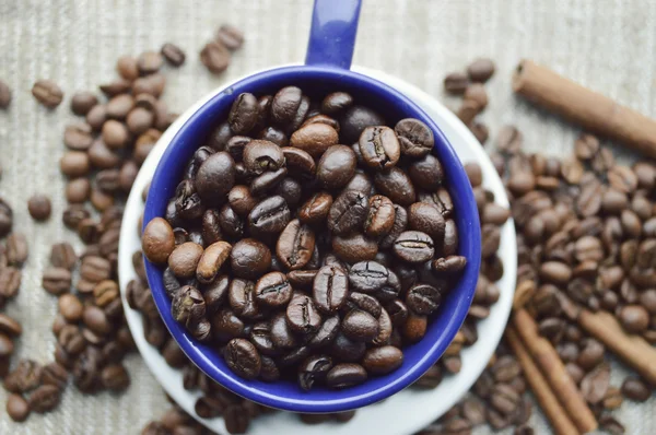 Cup full of coffee beans, cinnamon sticks, star anise, closeup — Stock Photo, Image