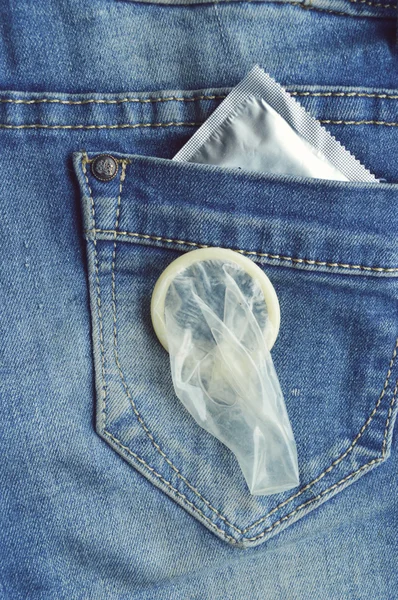 Condom on blue jeans pocket — Stock Photo, Image