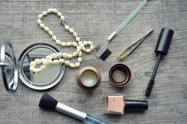 Maquillaje Cepillo de delineador de ojos con botella, conjunto de cosméticos, maquillaje y cepillos, polvo, hojaldre, rímel, delineador de ojos en la mesa de madera — Foto de Stock