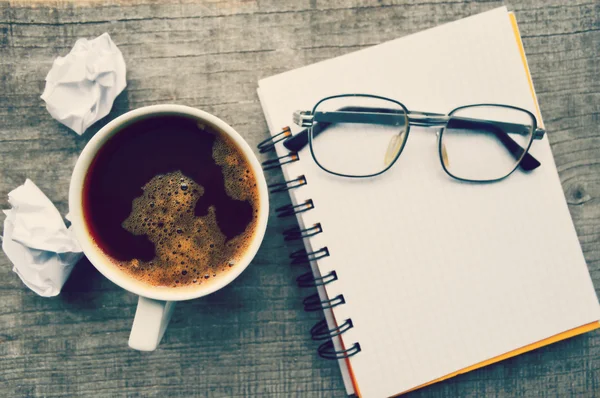 Libro electrónico rojo, Bloc de notas, vasos de lectura, taza de café caliente sobre fondo de madera — Foto de Stock