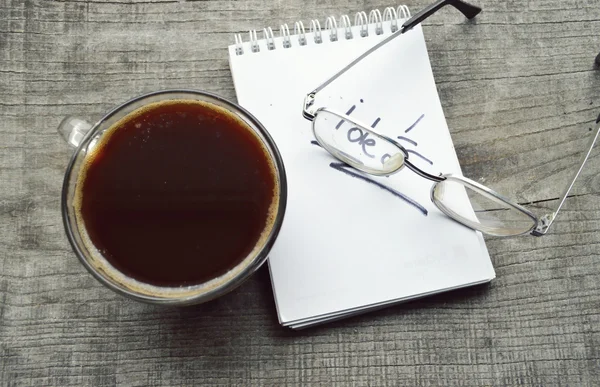Red e-book, Bloco de notas, óculos de leitura, xícara de café quente em fundo de madeira — Fotografia de Stock