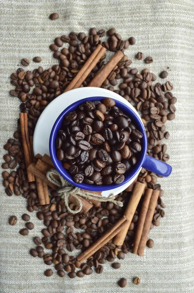 Tazza piena di chicchi di caffè, bastoncini di cannella, anice stellato, primo piano — Foto Stock