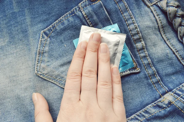 Condoom in blue jeans zak — Stockfoto