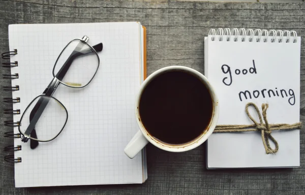 E-book.Notepad, óculos de leitura, xícara quente de café no fundo de madeira . — Fotografia de Stock