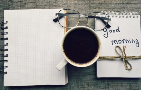 E-book.Notepad, óculos de leitura, xícara quente de café no fundo de madeira . — Fotografia de Stock