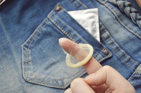 Condom on female finger — Stock Photo, Image