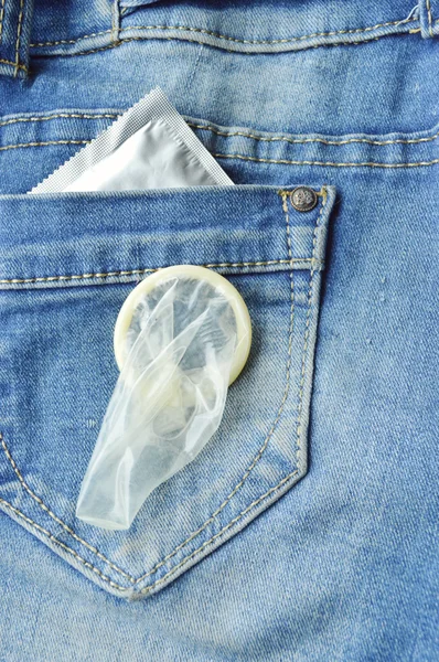 Презерватив в синих джинсах — стоковое фото