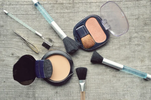 Maquillaje Cepillo de delineador de ojos con botella, conjunto de cosméticos, maquillaje y cepillos, polvo, hojaldre, rímel, delineador de ojos en la mesa de madera — Foto de Stock