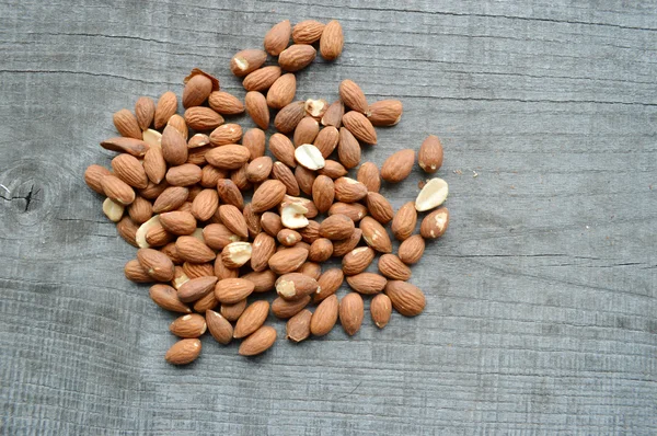 Almonds closeup on wooden background — Stock Photo, Image