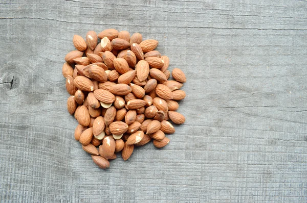 Almonds closeup on wooden background — Stock Photo, Image