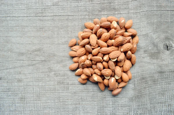 Almonds closeup on wooden background — Stock Photo, Image