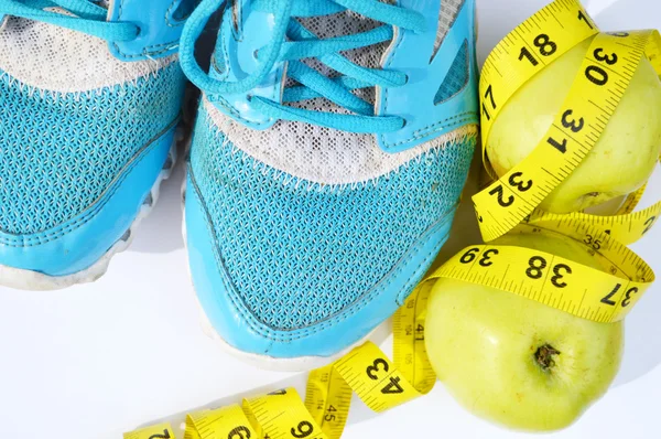 Turnschuhe, Zentimeter, rote Äpfel, Gewichtsverlust, Laufen, gesunde Ernährung, gesunder Lebensstil — Stockfoto