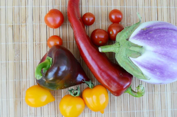 Legume, alimente sănătoase, roșii mici roșii și galbene, piper roșu, chili, vinete pe un fundal din lemn — Fotografie, imagine de stoc