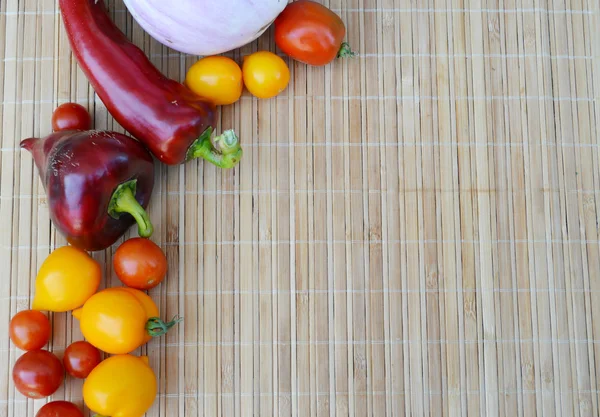 Legumes, comida saudável, pequenos tomates vermelhos e amarelos, pimenta vermelha, pimenta, berinjela em um fundo de madeira — Fotografia de Stock