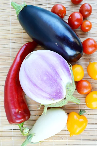 Legume, alimente sănătoase, roșii mici roșii și galbene, piper roșu, chili, vinete pe un fundal din lemn — Fotografie, imagine de stoc