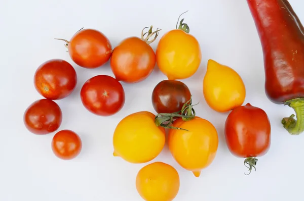 Zelenina, zdravé jídlo, malé červené a žluté rajčata, červená paprika, chilli, lilek na dřevěné pozadí — Stock fotografie