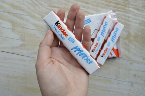 KYIV, UKRAINE - FEBRUARY 23 , 2015:Kinder chocolate bars on white wooden background.Kinder bars are produced by Ferrero which was founded in 1946. — Stock Photo, Image