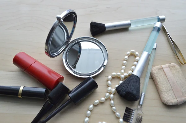 Brosse à eye-liner maquillage avec flacon, set de cosmétiques, maquillage et brosses, poudre, bouffée, mascara, eye-liner sur table en bois — Photo