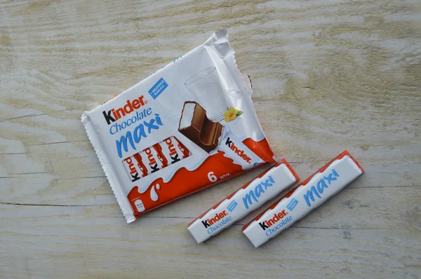 KYIV, UKRAINE - FEBRUARY 23 , 2015:Kinder chocolate bars on white wooden background.Kinder bars are produced by Ferrero which was founded in 1946. — Stock Photo, Image