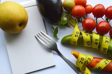 Sebze ve meyve kilo kaybı, bir ölçüm bandı, diyet, kilo kaybı, ölçüm bandı, sağlıklı beslenme, sağlıklı yaşam konsepti. Not Defteri, günlük, patlıcan, elma, armut