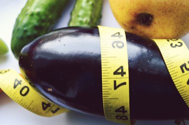 Sebze ve meyve kilo kaybı, bir ölçüm bandı, diyet, kilo kaybı, ölçüm bandı, sağlıklı beslenme, sağlıklı yaşam konsepti. Not Defteri, günlük, patlıcan, elma, armut