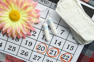 Kadın hijyen koruma, kırmızı bir arka plan üzerinde pamuk tampon, turuncu Gerber, sıhhi yastıkları ile yakın-up.menstruation takvimi