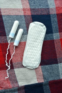 Kadın hijyen koruma, kırmızı bir arka plan üzerinde pamuk tampon, turuncu Gerber, sıhhi yastıkları ile yakın-up.menstruation takvimi