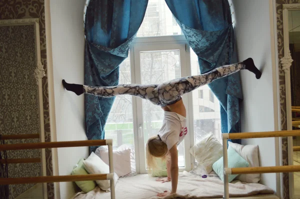 Young, beautiful, athletic girl makes workout.stretching, warm-up, flexibility, plastic, acrobatics, gymnastics — стоковое фото