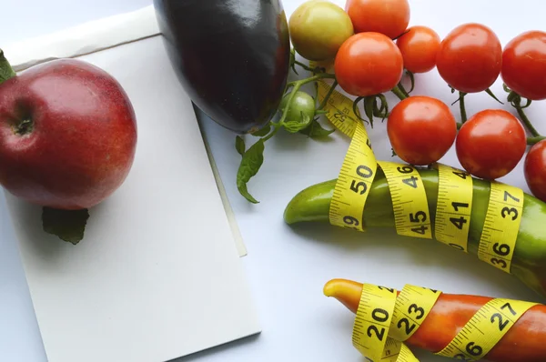 Verduras y frutas para bajar de peso, una cinta métrica, dieta, pérdida de peso, cinta métrica, alimentación saludable, concepto de estilo de vida saludable.Bloc de notas, diario, berenjena, manzana, pera —  Fotos de Stock