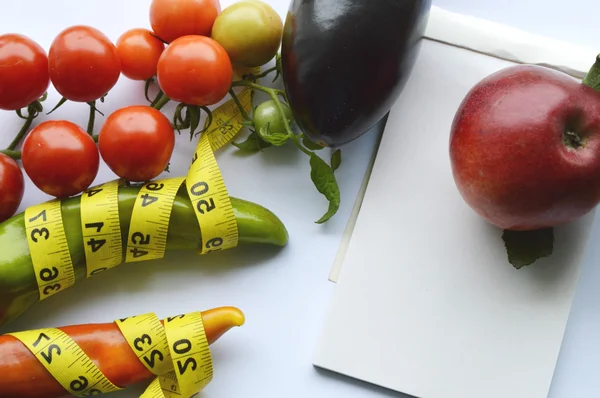 Verduras y frutas para bajar de peso, una cinta métrica, dieta, pérdida de peso, cinta métrica, alimentación saludable, concepto de estilo de vida saludable.Bloc de notas, diario, berenjena, manzana, pera — Foto de Stock