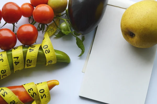 Verduras y frutas para bajar de peso, una cinta métrica, dieta, pérdida de peso, cinta métrica, alimentación saludable, concepto de estilo de vida saludable.Bloc de notas, diario, berenjena, manzana, pera —  Fotos de Stock