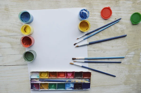 Set of brushes and paints on wooden table — Stock Photo, Image