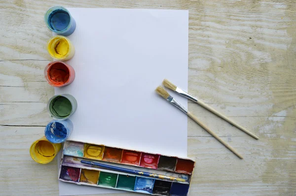 Set of brushes and paints on wooden table — Stock Photo, Image